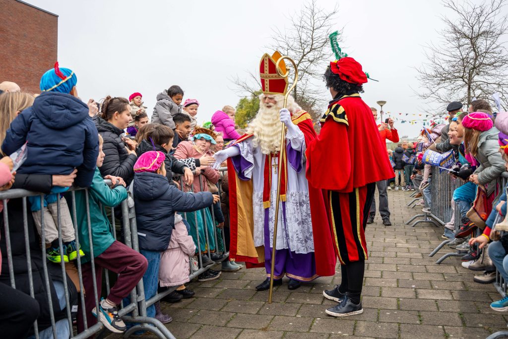 Sinterklaas en Zwarte Piet ontmoeten kinderen tijdens intocht in Roelofarendsveen.